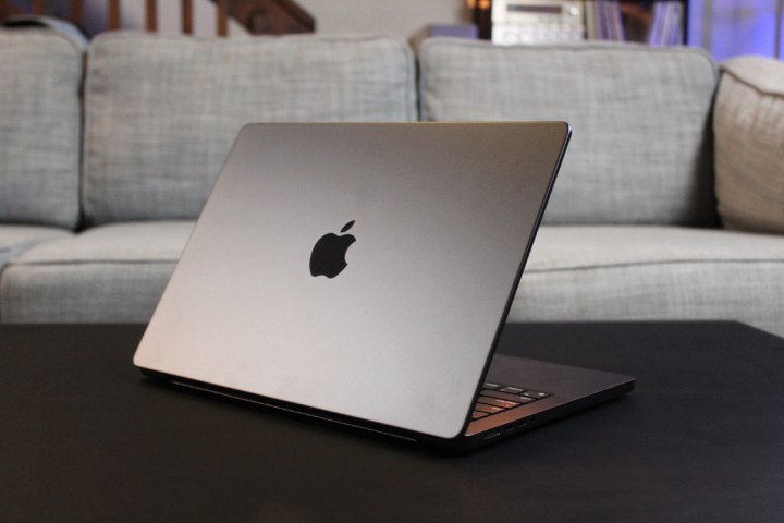 Der Deckel des MacBook Pro auf einem schwarzen Tisch.