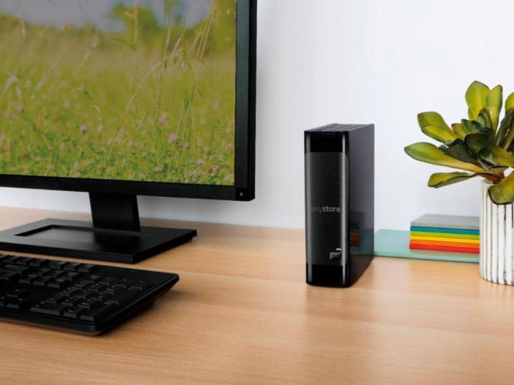 Die externe WD Easystore USB 3.0-Festplatte neben einem Monitor und einer Tastatur auf einem Schreibtisch.