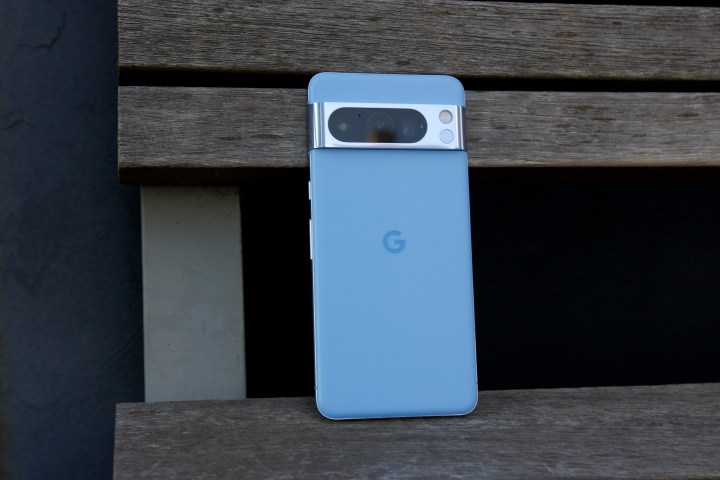 Das Google Pixel 8 Pro sitzt aufrecht auf einer Parkbank.
