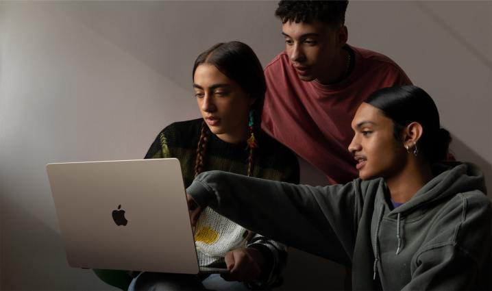 Drei Personen sitzen vor einem 15-Zoll MacBook Air, das von hinten gesehen wird.