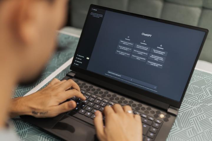 Eine Person tippt auf einem Laptop, auf dem die generative KI-Website von ChatGPT angezeigt wird.
