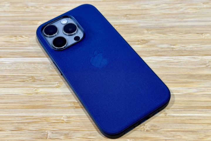 Pacific Blue FineWoven-Hülle auf einem iPhone 15 Pro aus natürlichem Titan auf einem Holztisch.