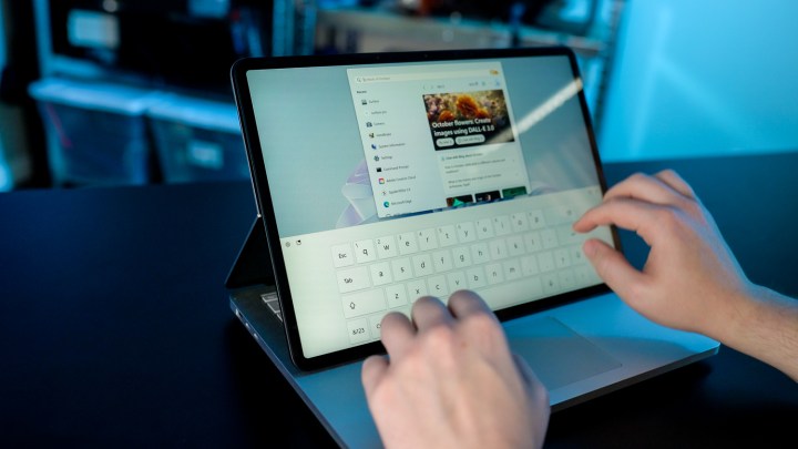 Jemand tippt auf dem Touchscreen des Surface Laptop Studio 2.