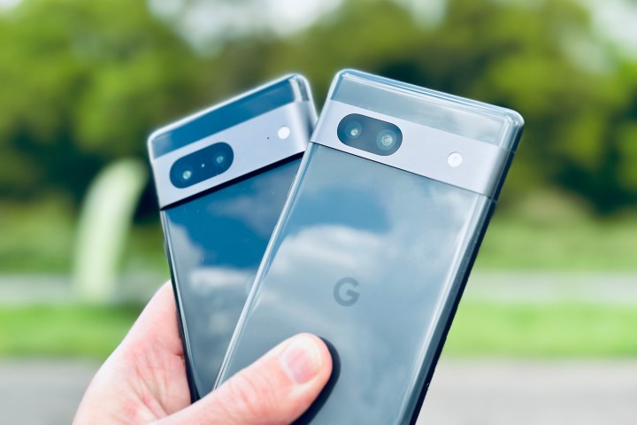 Das Google Pixel 7 und Pixel 7a in der Hand einer Person.