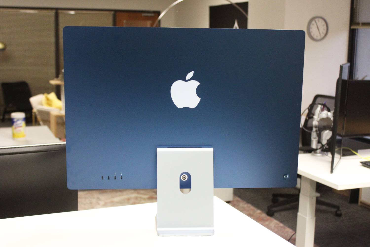 Die Rückseite des blauen iMac auf einem Schreibtisch in einem Büro.