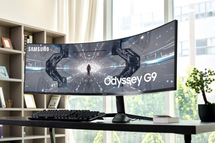 Der Samsung Odyssey G9 Monitor auf einem Schreibtisch in einer Wohnung.