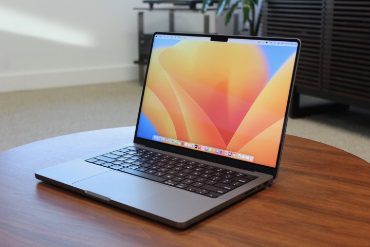 Das geöffnete MacBook Pro liegt auf einem Holztisch.