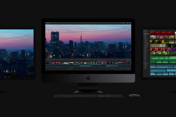 Ein Apple iMac Pro in einem dunklen Raum, flankiert von zwei Monitoren, einer auf jeder Seite.