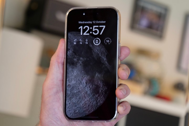 iPhone 14 Pro zeigt den Mond immer auf dem Bildschirm, gehalten in der Hand eines Mannes.