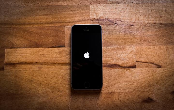 Ein iPhone liegt auf einem Holztisch.