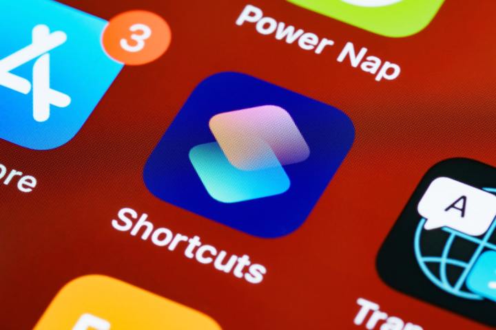 Eine Nahaufnahme der Shortcuts-App auf einem Apple-Gerät vor einem roten Hintergrund.