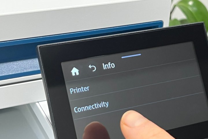 Ein Finger zeigt auf die Konnektivitätsmenüeinstellung eines Druckers.