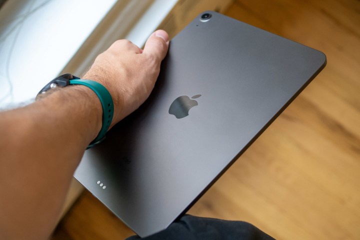 Der Arm einer Person hält ein Apple iPad Air 2020.