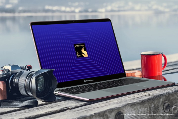Ein Laptop und eine Kamera auf einem Tisch mit einem Qualcomm-Logo auf dem Bildschirm.