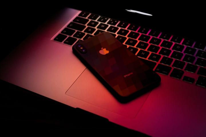Ein MacBook und ein iPhone in dunkelrotem Licht.