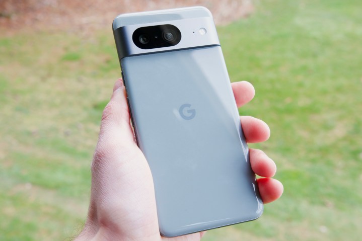 Jemand hält das Google Pixel 8 nach draußen und zeigt die Rückseite des Telefons.