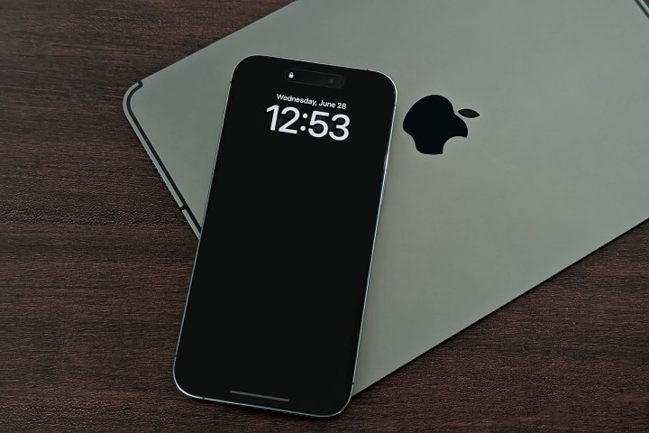 Das iPhone 14 Pro Max liegt auf dem iPad und zeigt ein ständig eingeschaltetes Display mit deaktivierter Hintergrundeinstellung.
