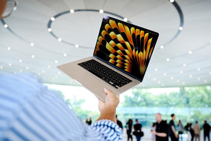 Eine Person hält ein MacBook Air auf der Worldwide Developer's Conference (WWDC) von Apple im Jahr 2023.