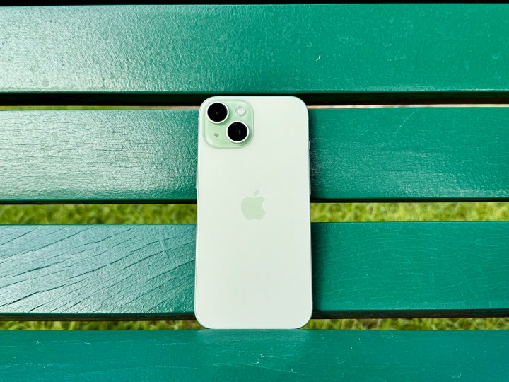 Ein grünes iPhone 15 auf einer grünen Bank.