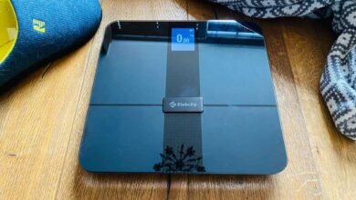 Etekcity smart scale on a floor next to a towel and slippers