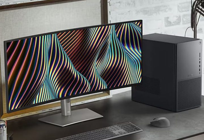 Der Dell XPS-Desktop auf einem Schreibtisch neben einem gebogenen Monitor.