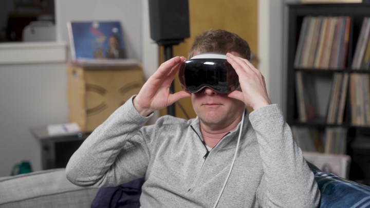 Ein Mann passt ein Apple Vision Pro-Headset über seine Augen.