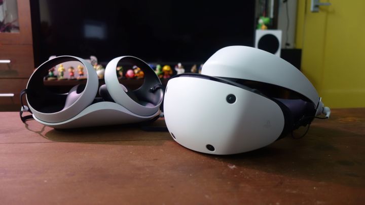Die PlayStation VR2 steht neben Sense-Controllern auf einem Tisch.