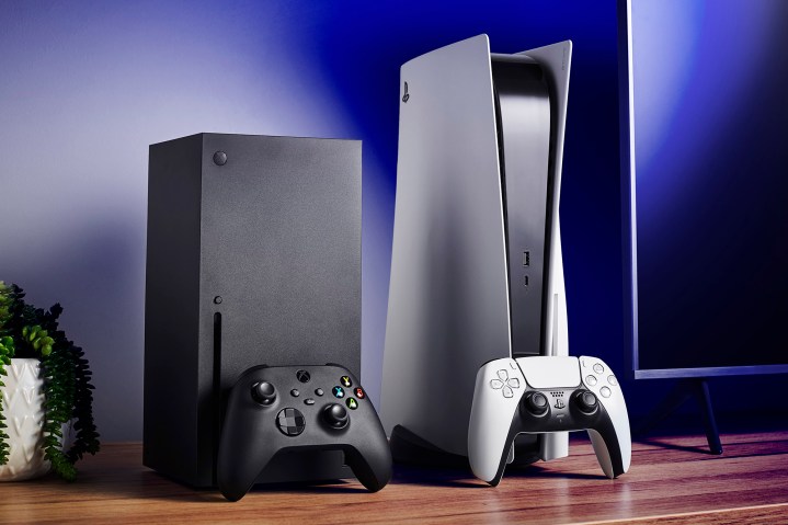 Wohnzimmer mit Heimvideospielkonsolen Microsoft Xbox Series X (L) und Sony PlayStation 5 sowie Fernseher und Soundbar.