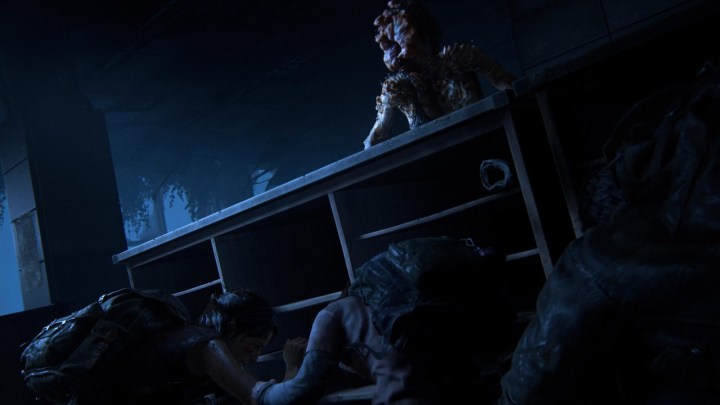 Ellie und Joel verstecken sich im The Last of Us Remake hinter einem Schreibtisch vor einem Klicker.