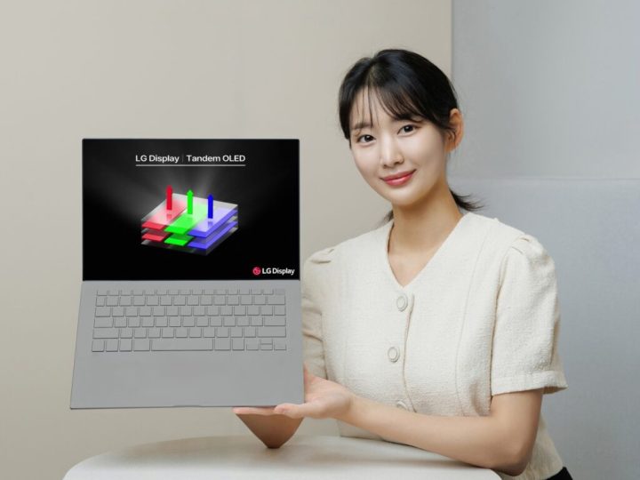 Eine Frau hält einen Laptop mit dem LG Tandem OLED-Logo.
