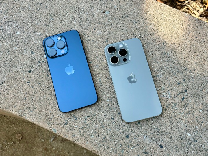 iPhone 15 Pros aus blauem Titan (links) und natürlichem Titan auf einer Betonbank.